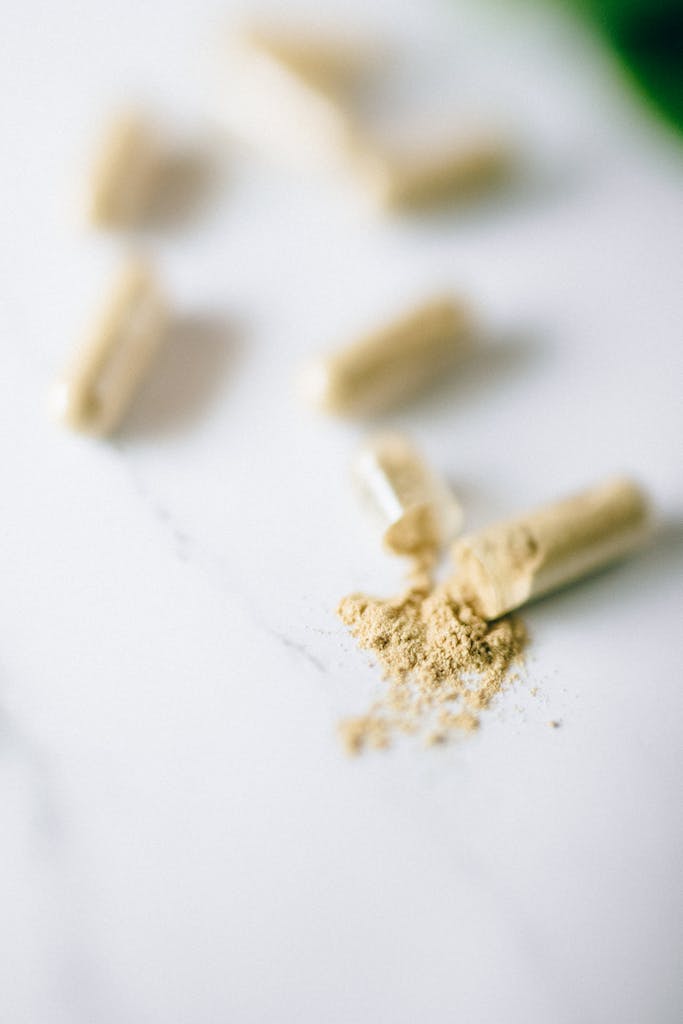 Close-up view of open capsules spilling powder on a marble surface. Ideal for health and supplement topics.