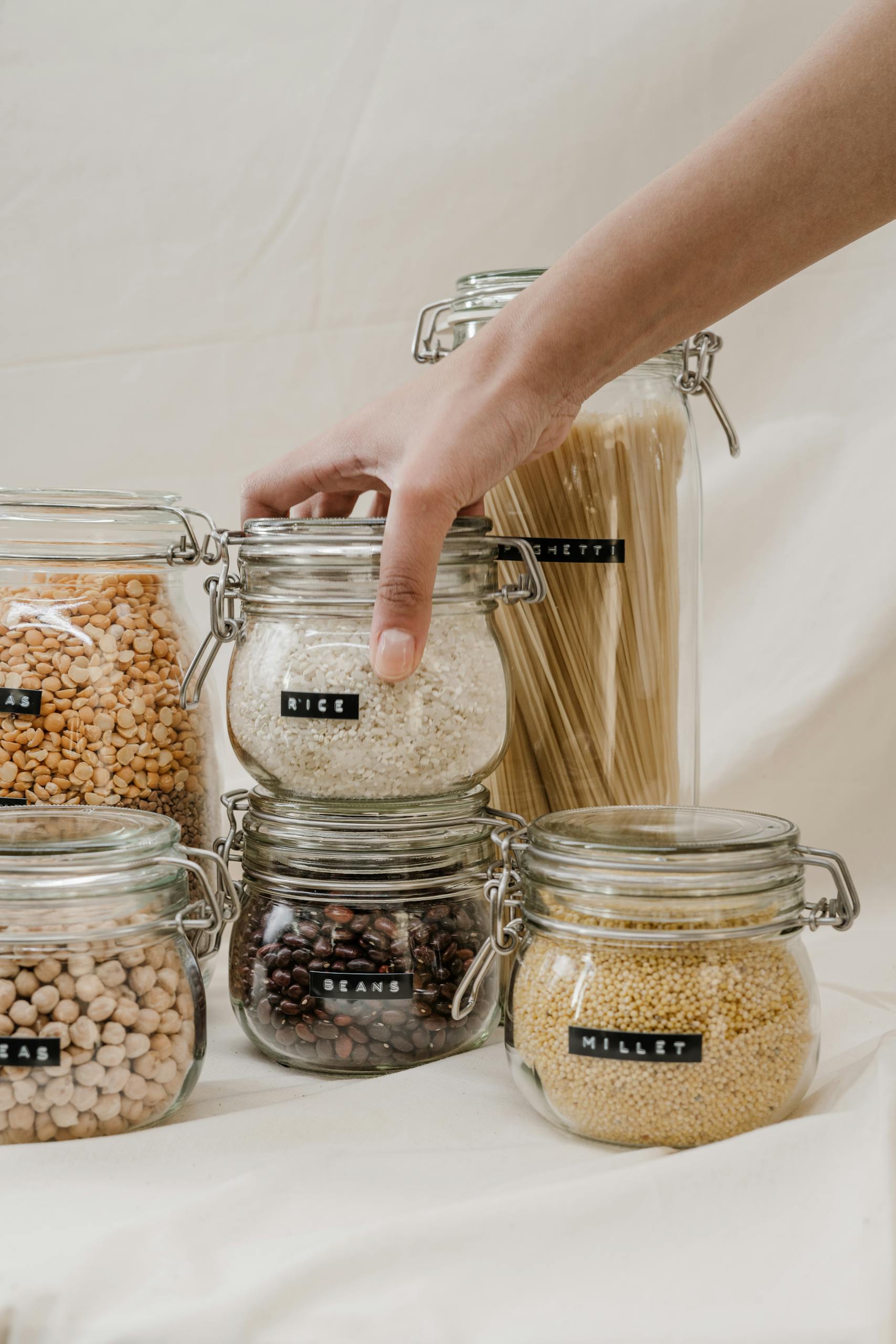 Eco-friendly storage jars filled with grains, beans, and pasta, promoting a zero waste lifestyle.